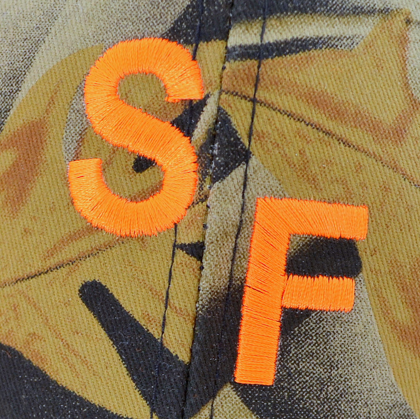 Orange letters SF on camouflage background